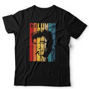 May include: Black t-shirt featuring a retro-style graphic of a man with a cigarette, with the word "COLUMBO" in bold letters. The design uses vertical stripes in red, orange, yellow, green, and blue.