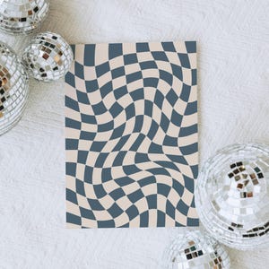 May include: A decorative print featuring a distorted checkerboard pattern in shades of blue and beige. The print is rectangular and surrounded by several mirrored disco balls, creating a retro aesthetic.