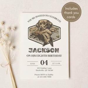 May include: A cream-colored birthday invitation with a hunting theme. The invitation features a graphic of a dog carrying a duck, the name "Jackson", and event details. Includes thank you cards.