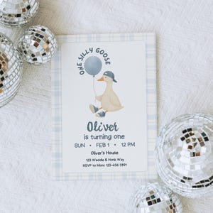 Op de afbeelding: Een verjaardagsuitnodiging met een cartoon gans die een ballon vasthoudt. De uitnodiging heeft een blauwe geruite rand en bevat de tekst "One Silly Goose", "Oliver is turning one" en evenementdetails. Zilveren discoballen zijn verspreid rond de uitnodiging.