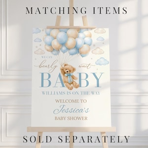 Puede incluir: Un letrero de baby shower sobre un caballete de madera. El letrero presenta un osito de peluche sosteniendo globos, con el texto "We can bearly wait BABY". El letrero tambi&eacute;n incluye el texto "Williams is on the way" y "Welcome to Jessica's Baby Shower."