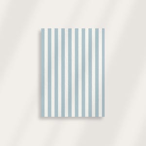May include: A rectangular object with a vertical striped pattern in light blue and white. The stripes are evenly spaced and run the entire length of the object. The background is a plain, off-white color.