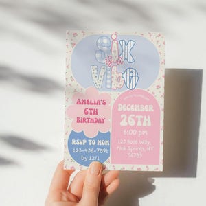 Op de afbeelding: Een verjaardagsuitnodiging met de tekst "Six is a Vibe" in een speels lettertype. De uitnodiging bevat details voor Amelia's 6e verjaardag, met een bloemenachtergrond en roze en blauwe accenten. De datum is 26 december.