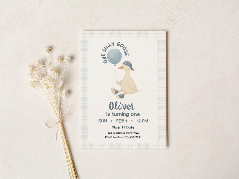 One silly goose boy first birthday invitation mockup on neutral stone background, blue plaid border and cream textured card featuring a cute goose in sneakers and a backwards cap holding a blue balloon, text reading “One Silly Goose” and “Oliver is turning one,” modern minimalist design for editable Canva template, printable invite, digital download baby boy birthday party.
