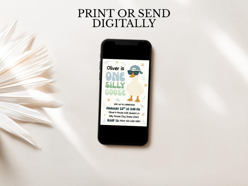 May include: A smartphone displays a digital invitation for a first birthday party. The invitation features a cartoon goose wearing sunglasses and a cap. Text on the invitation reads "Oliver is ONE SILLY GOOSE" and includes party details.