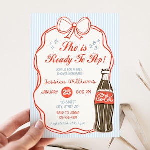 May include: Baby shower invitation with a vintage design. The invitation features a red and white Coca-Cola bottle illustration, a red bow, and the text "She is Ready To Pop!" on a blue striped background. The invitation includes the date, time, and location.