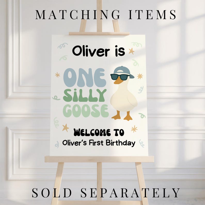 May include: A white sign on a wooden easel with the text "MATCHING ITEMS" at the top and "SOLD SEPARATELY" at the bottom. The sign reads "Oliver is ONE SILLY GOOSE" with a cartoon goose wearing sunglasses and a hat. The sign says "WELCOME TO Oliver's First Birthday."