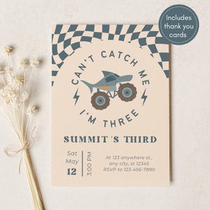 May include: A birthday invitation with a shark-themed monster truck design. The text reads "Can't Catch Me, I'm Three" and includes event details. The invitation is beige with blue and brown accents. Includes thank you cards.
