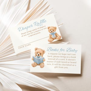 May include: Two baby shower cards with text and illustrations. One card reads "Diaper Raffle" and features a teddy bear with a blue bow. The other card says "Books for Baby" and shows a teddy bear reading a book.