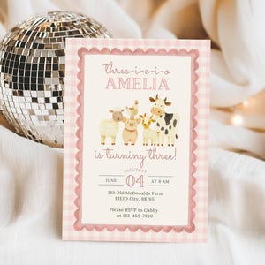 Close up of girl barnyard invite with pink barn, farm animals, and Three I E I O wording for cute farm themed 3rd birthday party, printable digital template.