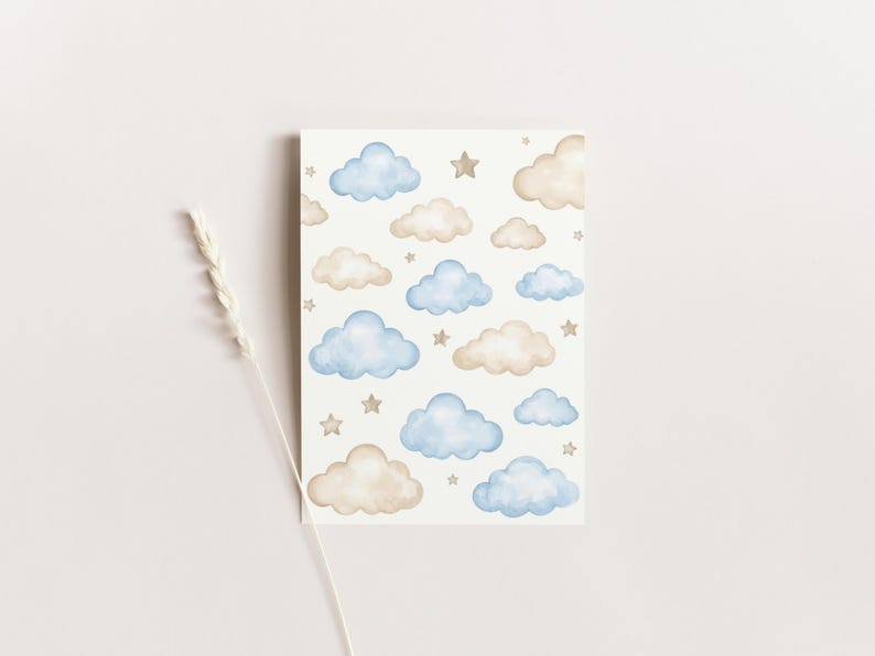 Puede incluir: Una tarjeta rectangular con un dise&ntilde;o de acuarela de nubes azules y beige y peque&ntilde;as estrellas doradas sobre un fondo blanco. La tarjeta tiene una est&eacute;tica suave y so&ntilde;adora, adecuada para papeler&iacute;a o decoraci&oacute;n de guarder&iacute;a.