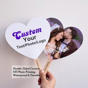 May include: Heart-shaped fan with a photo of a couple kissing, and a white heart-shaped fan with the text "Custom Your Text/Photo/Logo" in purple. The fan has a wooden handle and the text "Custom your" printed on the handle.