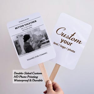 May include: Two white, double-sided custom fans with wooden handles. One fan features a black and white photo and text: "ETHAN & OLIVIA, BETTER TOGETHER, DEC 12, 2026 6:00PM, THE PLAZA HOTEL, THANKS FOR COMING." The other fan says "Custom your text/logo/photo."