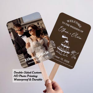 May include: Two double-sided wedding fans. One fan features a photo of a couple with the names Ethan & Olivia and the date. The other fan has the words "Welcome to the Wedding of Ethan & Olivia" and the date.