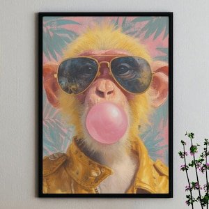 May include: A framed art print of a monkey wearing aviator sunglasses and a yellow leather jacket, blowing a pink bubblegum bubble. The background has a soft, colourful design with palm leaves.