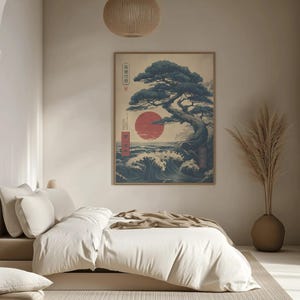 May include: A framed Japanese art print featuring a bonsai tree, a red sun, and ocean waves. The artwork is displayed in a bedroom, above a bed with white bedding. The room has a neutral colour scheme with a beige rug and a decorative vase.