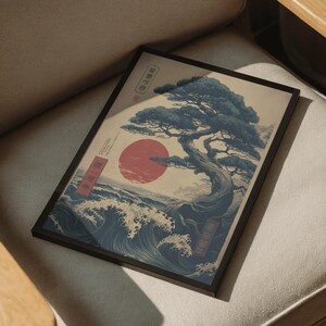 May include: Framed art print with a Japanese design. It shows a stylized tree, a red sun, and ocean waves. The colour scheme includes blue, red, and beige. The print is in a black frame, suitable for various interior styles.
