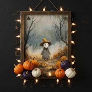 Może przedstawiać: Oprawione dzieło sztuki o tematyce Halloween, przedstawiające fantazyjną postać w kapeluszu i płaszczu, otoczoną dyniami. Dzieło sztuki jest ozdobione łańcuchem świetlnym i dekoracyjnymi metalowymi wycięciami nietoperzy, gwiazd i księżyców. Paleta kolorów obejmuje pomarańczowy, fioletowy, biały i brązowy.