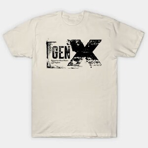 May include: A beige t-shirt with a black graphic print of the text "GEN X" in a distressed style. The text is surrounded by a black rectangle and includes the phrase "Raised on House Water & Neglect".