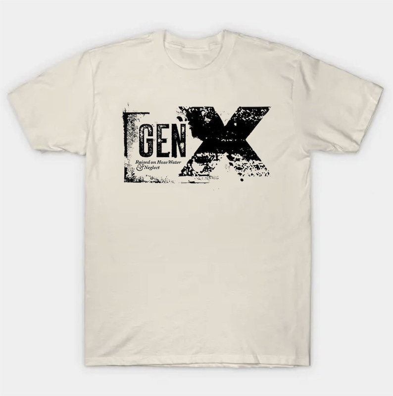 May include: A beige t-shirt with a black graphic print of the text "GEN X" in a distressed style. The text is surrounded by a black rectangle and includes the phrase "Raised on House Water & Neglect".