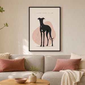 Peut inclure: Une affiche encadrée représentant un lévrier noir debout sur un fond beige clair avec une forme abstraite rose pâle et des dessins botaniques. Le texte "LONG LEGS CLUB" est imprimé en noir en haut de cette affiche rectangulaire.