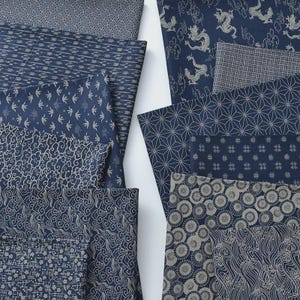 Puede incluir: Una variedad de muestras de tela azul marino con varios patrones. Los diseños incluyen formas geométricas, dragones, nubes y motivos florales en blanco y gris. Las telas están dispuestas sobre un fondo blanco.