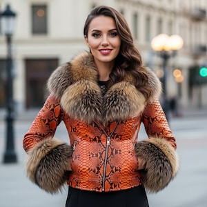 May include: An orange snakeskin-effect jacket with a fur collar and cuffs. The jacket features a zip closure and is worn over a black top. The fur trim is a mix of brown and tan.