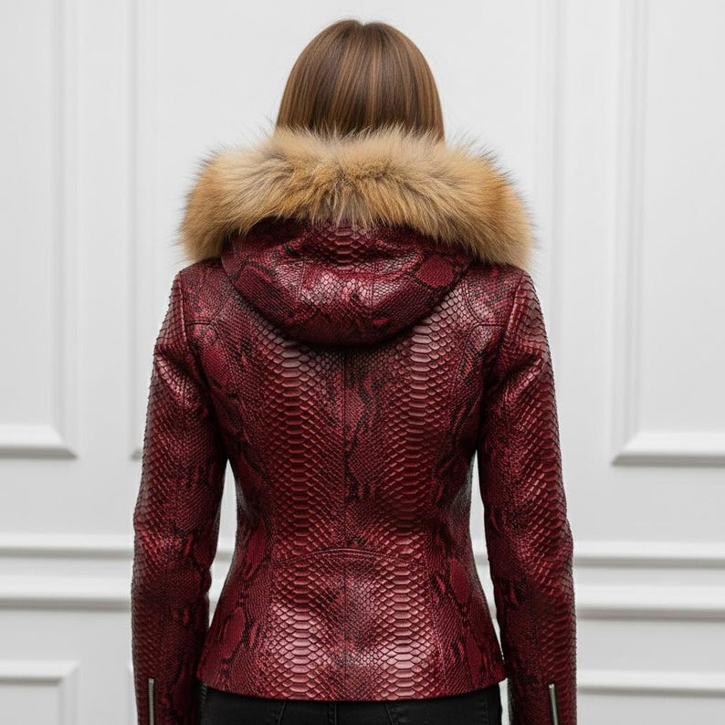 Puede incluir: Chaqueta de cuero burdeos con estampado de piel de serpiente, con capucha forrada de piel. La chaqueta tiene una silueta entallada, cierre de cremallera y un aspecto texturizado. El ribete de piel es de color marr&oacute;n claro.
