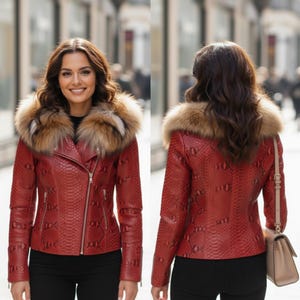 以下が含まれることがあります： 赤い革のジャケット、ヘビ柄、毛皮の襟付き。 ジャケットはジッパー開閉と長袖です。 モデルは黒いパンツを着用しています。