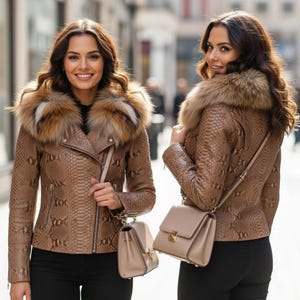 以下が含まれることがあります： 茶色のヘビ柄の革のジャケット、毛皮の襟付き。 ジャケットはジッパー開閉で、小さなベージュのハンドバッグはショルダーストラップ付き。 黒いパンツを履いています。