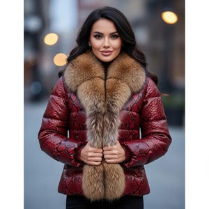 Può includere: Giacca trapuntata rossa con motivo a pelle di serpente e collo in pelliccia marrone. La giacca è abbottonata e ha maniche lunghe. Il collo in pelliccia si estende sulla parte anteriore della giacca.