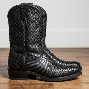 May include: A pair of black cowboy boots with a textured, snakeskin-like pattern. The boots have a classic Western design with a pointed toe and a stacked heel. The boots are made of leather and are suitable for various occasions.