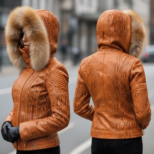 May include: A brown and tan snakeskin-effect leather jacket with a fur-trimmed hood. The jacket has a zip closure and is worn with black gloves. The image shows the front and back of the jacket, showcasing the textured pattern.
