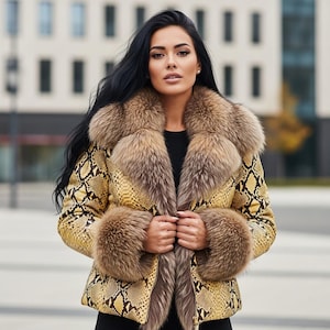 Pode incluir: Uma mulher usando um casaco amarelo e marrom com estampa de pele de cobra com gola e punhos de pele. O casaco está aberto, revelando um top preto. O fundo é um ambiente externo desfocado.