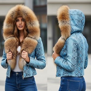 Könnte beinhalten: Hellblaue Jacke mit Schlangenmuster, mit einer großen Kapuze mit braunem Fell besetzt. Die Jacke hat einen Reißverschluss und wird mit einer blauen Jeans getragen. Der Fellbesatz erstreckt sich über die Vorderseite der Jacke.