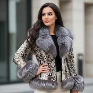 Könnte beinhalten: Jacke mit Schlangenmuster und grauem Pelzkragen und -bündchen. Die Jacke hat einen Reißverschluss und wird über einem schwarzen Oberteil getragen. Ein stilvolles Oberbekleidungsstück.