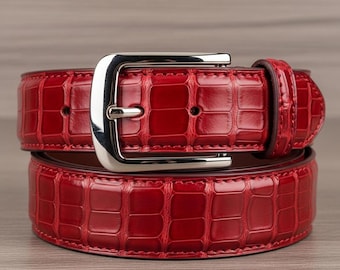 Cinto de couro vermelho com textura de crocodilo para homens e mulheres, com fivela prateada, um modelo marcante para ocasiões formais.