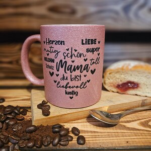 Glitzertasse in Rosa mit Text Mama, super, Liebe, Herzen, mutig etc. in Herzform auf der Tasse aufgebracht