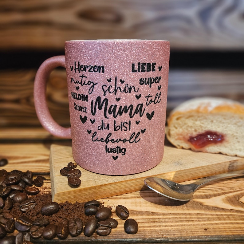 Glitzertasse in Rosa mit Text Mama, super, Liebe, Herzen, mutig etc. in Herzform auf der Tasse aufgebracht