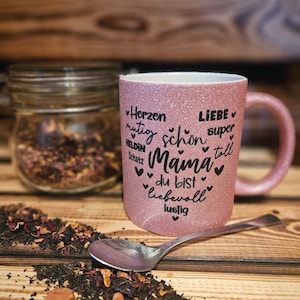 Glitzertasse in Rosa mit Text Mama, super, Liebe, Herzen, mutig etc. in Herzform auf der Tasse aufgebracht