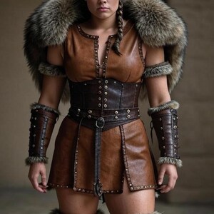 May include: A brown leather costume with fur trim, featuring a sleeveless top, skirt, and arm cuffs. The outfit includes a corset-style belt and fur accents around the shoulders and legs. The costume is detailed with metal studs and a decorative buckle.