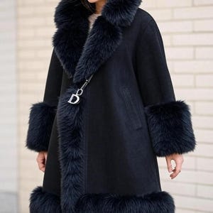 May include: A black coat with a fur collar, cuffs, and hem. The coat features a double-breasted design and a decorative clasp. The fur trim is a deep, rich black, contrasting with the coat's smooth fabric. A stylish outerwear piece.
