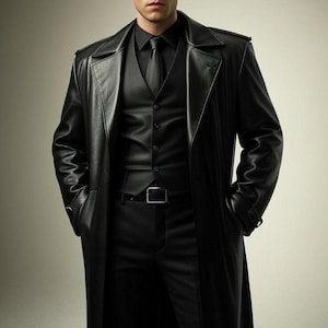 May include: A black leather trench coat, vest, dress shirt, tie, and trousers. The long coat has a notched collar and a belt. The outfit is all black and appears to be made of leather. The man is wearing a black outfit.