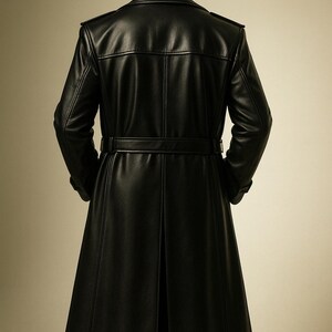 May include: A long, black leather coat with a belted waist and a split back. The coat has a classic trench coat design with a notched collar and shoulder epaulets. The coat is made of a smooth, shiny leather material.