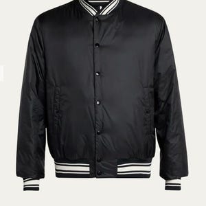 Puede incluir: Chaqueta bomber negra con un diseño clásico. Cuenta con cuello, puños y dobladillo acanalados con rayas blancas. La chaqueta tiene cierre de botones y dos bolsillos laterales. Una prenda de abrigo elegante y versátil.