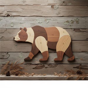 May include: Wooden bear puzzle with numbered pieces in shades of brown and tan. The bear is depicted in a walking pose, with each body section a different shade of wood. The puzzle is set against a rustic wooden background.