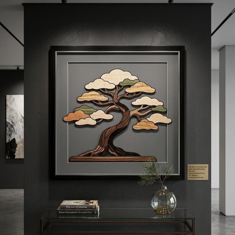 May include: A square wall art piece featuring a layered wooden bonsai tree with a dark brown trunk and light wood foliage in a black frame. The tree is set against a gray background. A small gold plaque with text is mounted on the wall nearby.