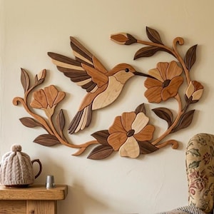 May include: A wall-mounted wooden art piece featuring a hummingbird in flight surrounded by floral branches. The design is crafted from various shades of natural wood, showcasing light, medium, and dark brown tones in a layered, mosaic-like composition.
