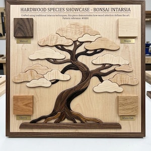 May include: A wooden intarsia wall art piece titled HARDWOOD SPECIES SHOWCASE - BONSAI INTARSIA. It features a central bonsai tree design made of light and dark wood segments, flanked by four labeled square wood samples: Walnut, Maple, Cherry, and White Oak.