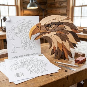 Könnte beinhalten: Eine Holzskulptur eines Adlerkopfes mit detailliertem Intarsien-Design, das verschiedene Holztöne aufweist. Die Skulptur wird zusammen mit Mustervorlagen mit der Aufschrift "EAGLE HEAD INTARSIA PATTERN" und Werkzeugen auf einer Holzwerkbank präsentiert. Der Schnabel des Adlers ist hellbraun.